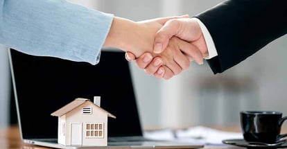 Loan officer and customer shaking hands after signing a contract