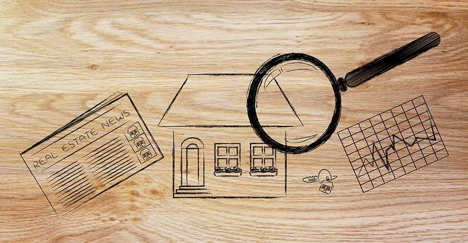 Magnifying glass analyzing a house