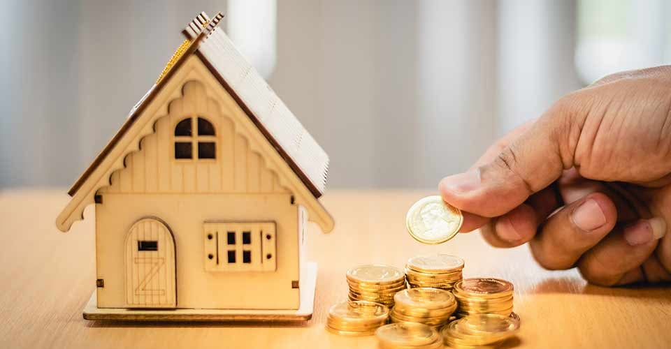 Man hand holding coins and modal house