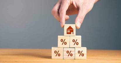Man holding wooden blocks with percent and house