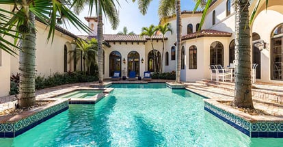 Mansion with Spanish architecture a large pool and palm trees