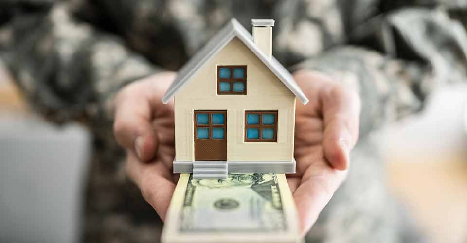 Military army man in uniform holding house model
