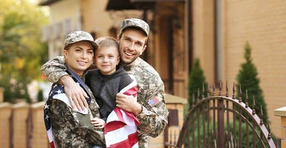 Military family outside their new home on a sunny day