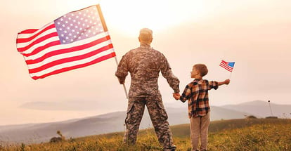 Military father and son holding an american flag