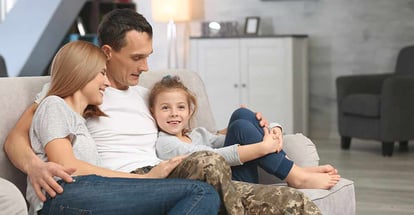 Military father with his family on sofa at new home