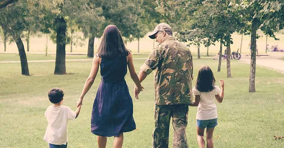 Military man and his family walking outside their home