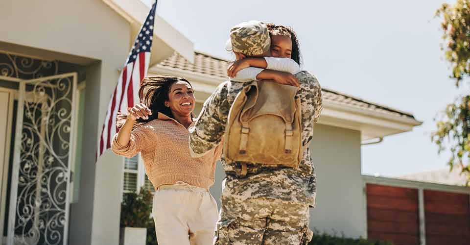 Military man receiving a warm welcome from his family at home