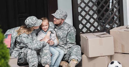 Military parents with daughter hugging and sitting on moving day