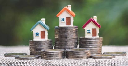 Mini house on stack of coins