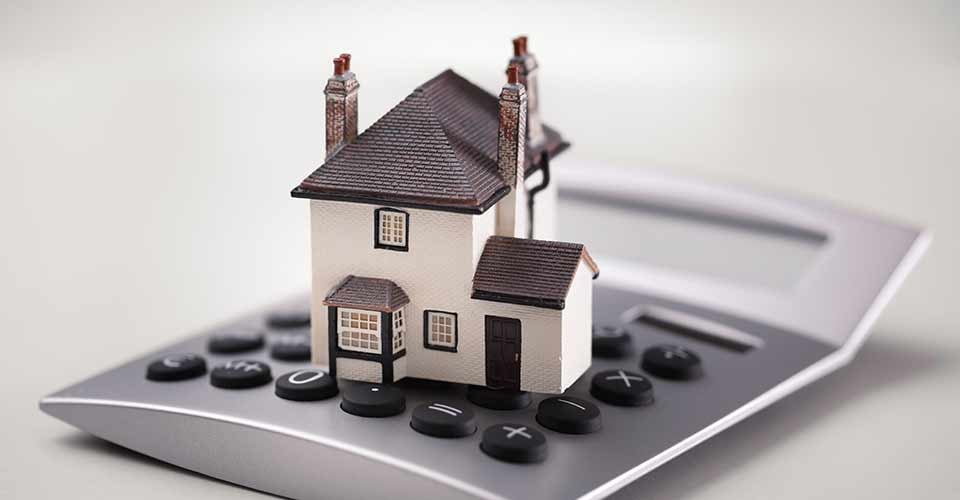 Miniature House resting on calculator