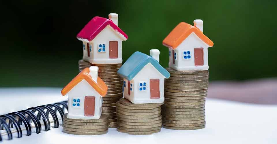 Miniature colorful house on stack coins and real estate growth