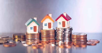 Miniature colorful house on stack coins