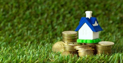 Miniature house with stack of gold coins to buy investment property