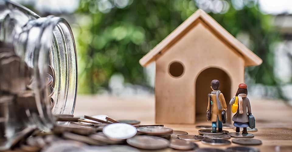 Miniature tiny home and money on wooden floor