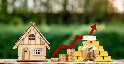 Model home and stack coin with upward red arrow for real estate investment