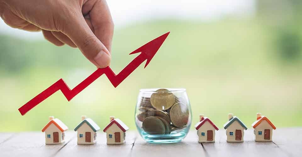 Model house and coins on table for property investment