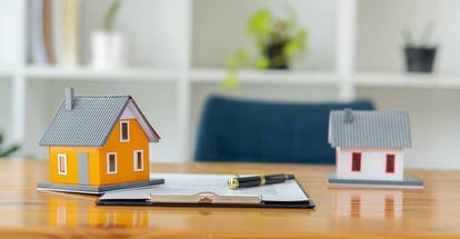 Model house and home purchase documents on the table