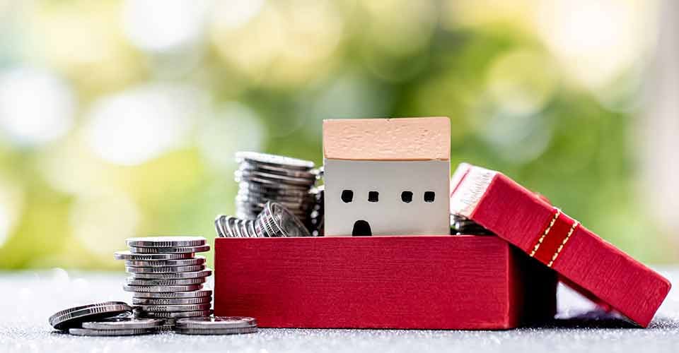 Model house and silver coins in boxes