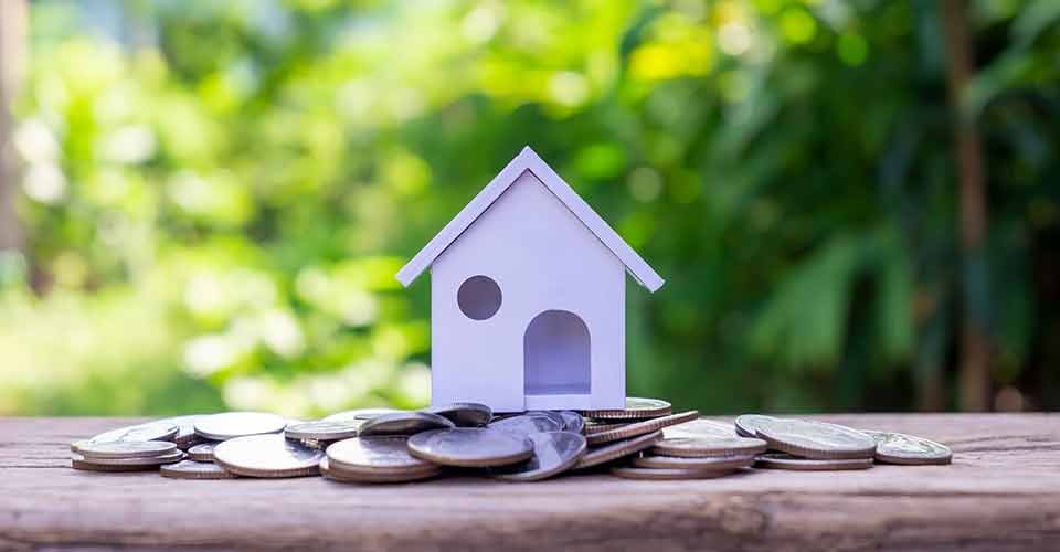Model house on a pile of coins