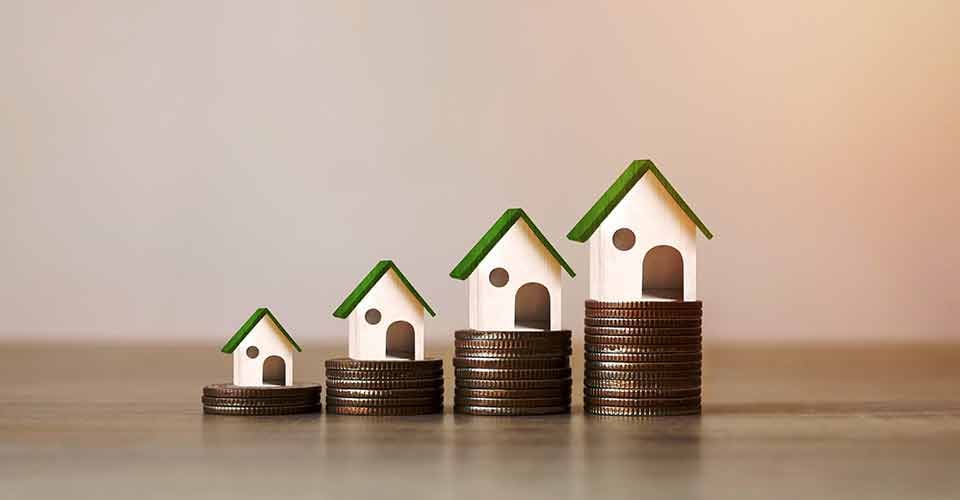 Model house on pile of coins