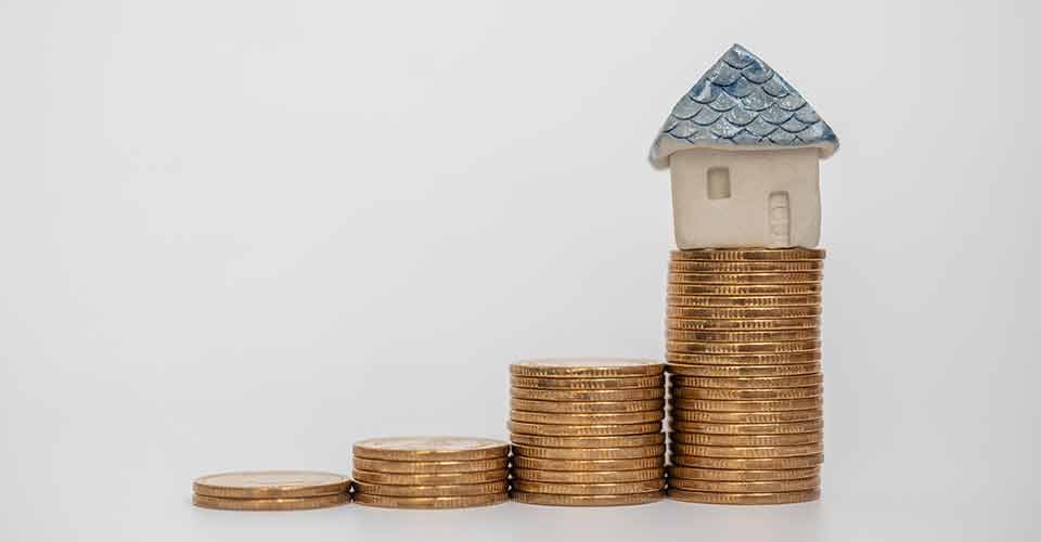 Model house on stack of gold coins