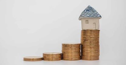 Model house on stack of gold coins