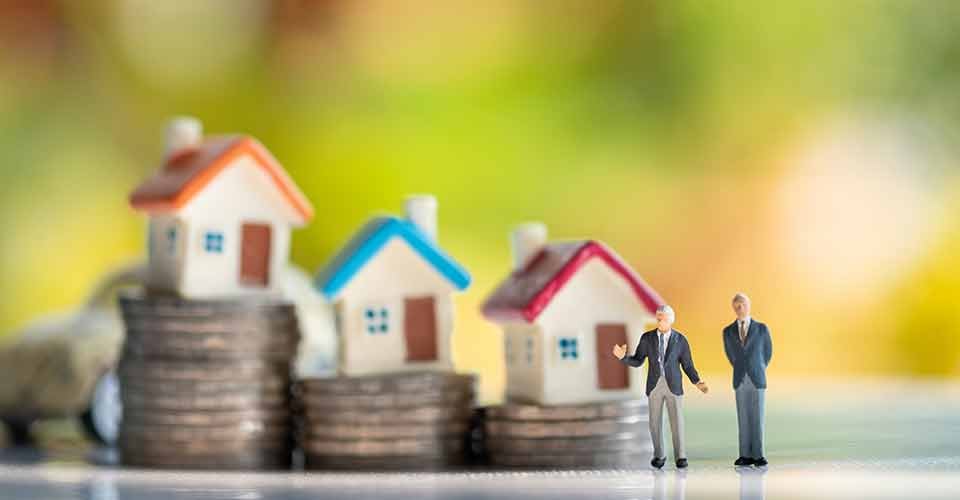 Model house on top of coin stacks with home buyer