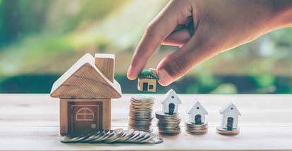Model house placed on coins for real estate investment