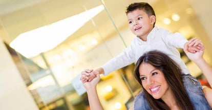 Mom carrying her son in her shoulders at the mall
