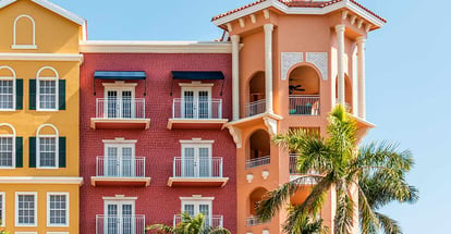 Multicolored buildings facade exterior with windows and palm trees in Florida