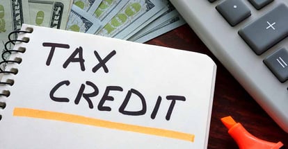 Notebook with tax credit sign on a table