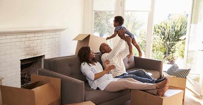 Parents Take a Break on Sofa With Son On Moving Day in their new home