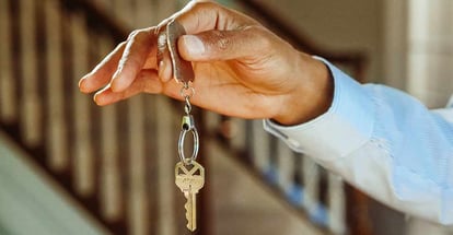 Person Holding a Silver Keychain with a Key