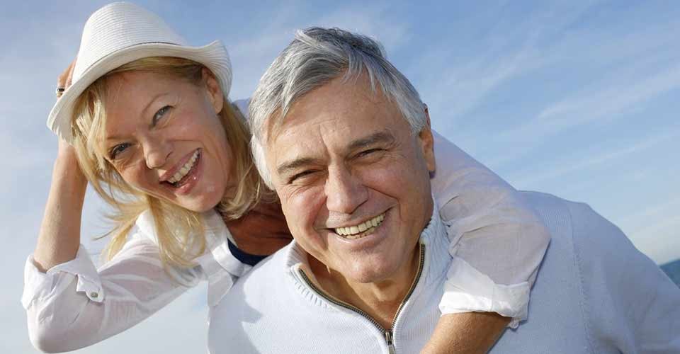 Portrait of cheerful senior couple having fun at the beach