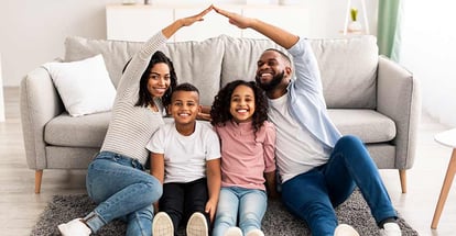 Portrait of smiling African American parents making symbolic roof of hands above their happy children