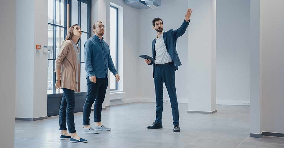 Real Estate Agent Showing a New Empty Space to Young Couple