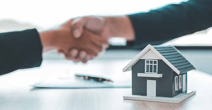 Real estate agent and customer shake hands after signing a contract to buy a house