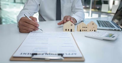Real estate agent and customer signing contract to buy house