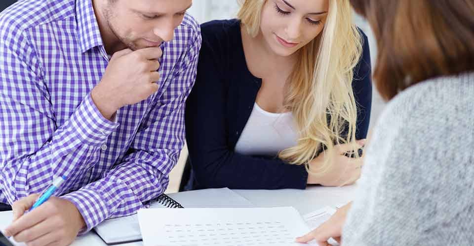 Real estate agent explaning about mortgages to a young couple