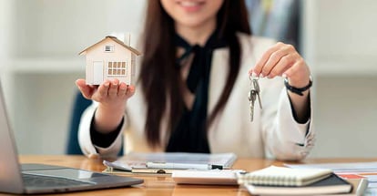 Real estate agent hand over new home keys to a buyer