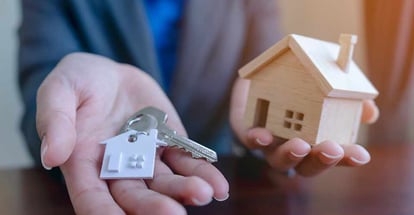 Real estate agent holding house model and keys