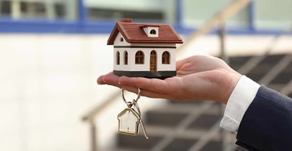 Real estate agent holding key and house model