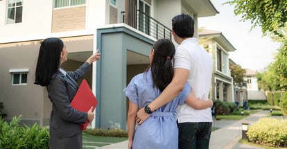 Real estate agent showing a house to young couple looking to buy it