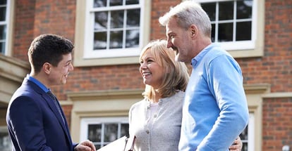 Realtor Showing Mature Couple Around House For Sale