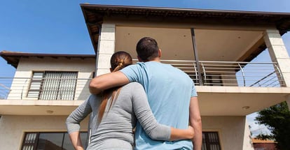 Rear view of young couple looking at their new house
