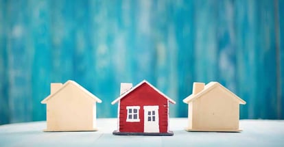 Red house model on blue wooden background