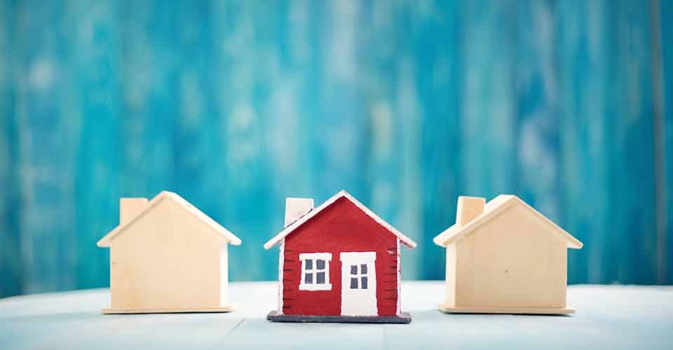 Red house model on blue wooden background