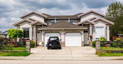 Residential duplex townhouse with black car parked on concrete driveway in Florida