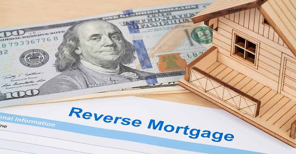Reverse mortgage application form with dollar bills and model house