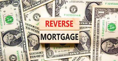Reverse mortgage words on wooden blocks and dollar bills background